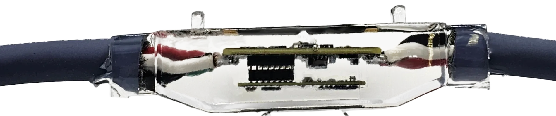 The sensor node from the side, showing two stacked boards inside the clear epoxy shell